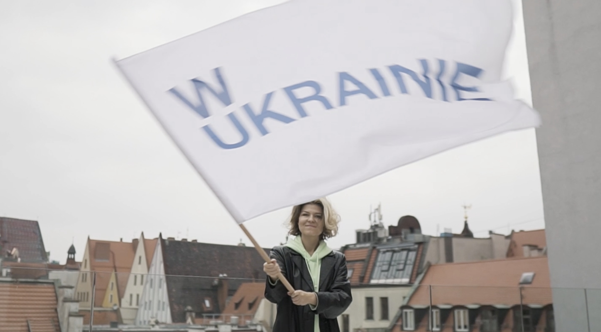 Yulia Krivich trzymająca flagę z napisem "W Ukrainie"