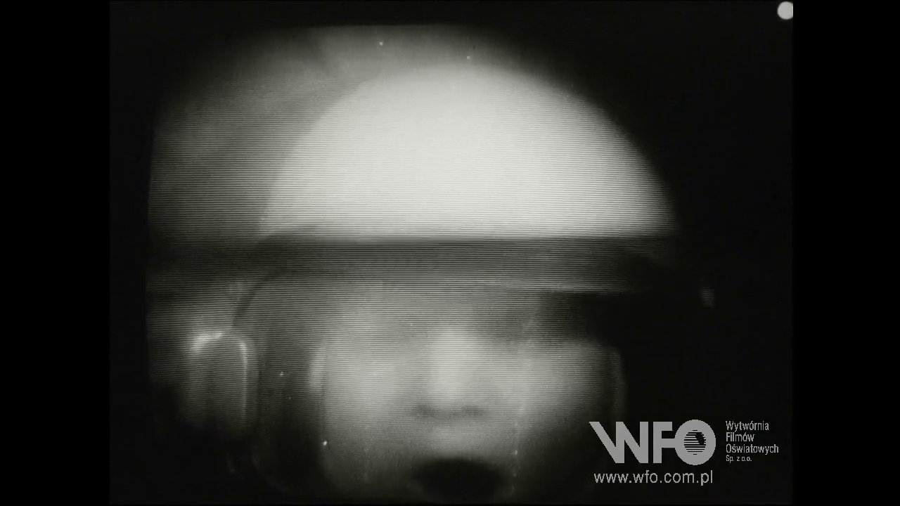 czarno-biały kadr z filmu edukacyjnego z lat 70. - rozmyta twarz astronauty