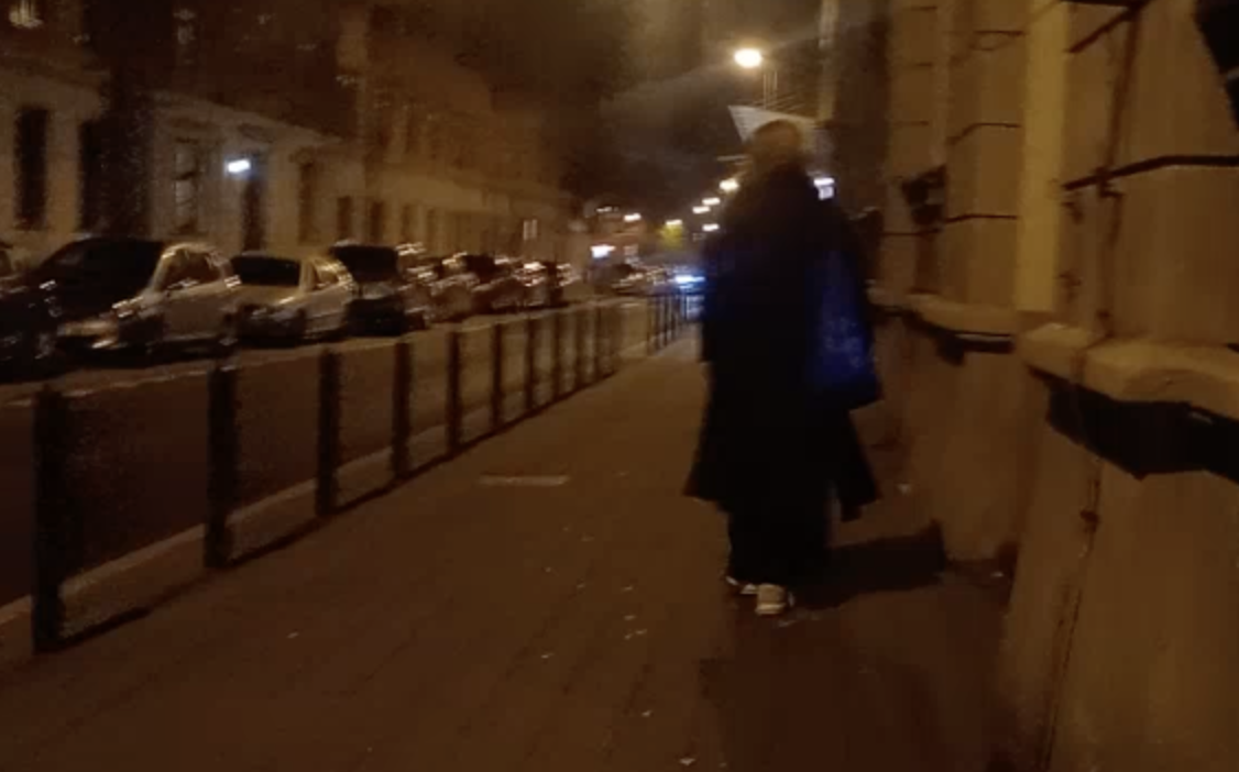 widziana od tyłu kobieta idąca ulicą